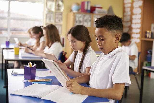 Primary classroom with children on desks